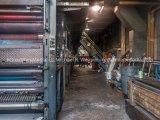 Workmen scrapping the press that once printed the Alton Telegraph remove it one piece at a time. The rubber mats that transferred ink to paper are still visible on the press.