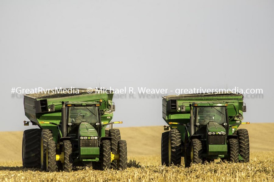 Two John Deere tractors sit in a field at harvest time. John Deere has been lobbying hard against any legislation that gives anyone but dealers the ability to diagnose or fix problems on their tractors.