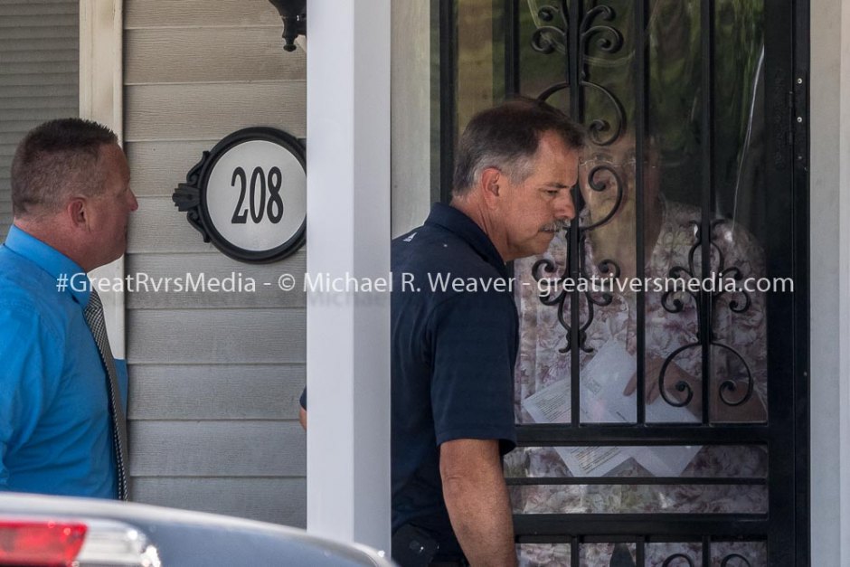 Resident in home next to shooting listens through her door as Jerseyville officials explain what they will be doing at crime scene.