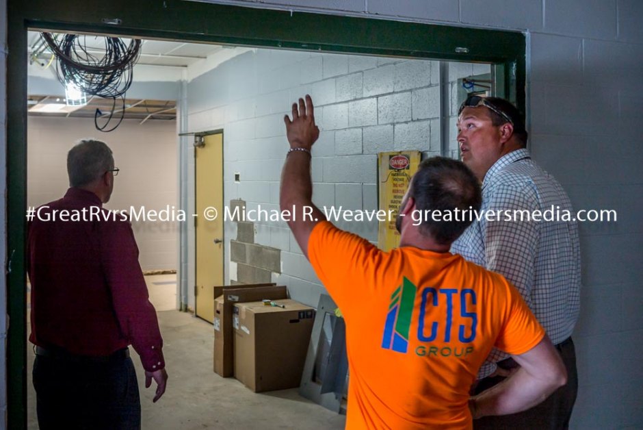 North Greene Superintendent Mark Scott on far right discusses renovations with construction crew member as school board member to the left looks down hallway.