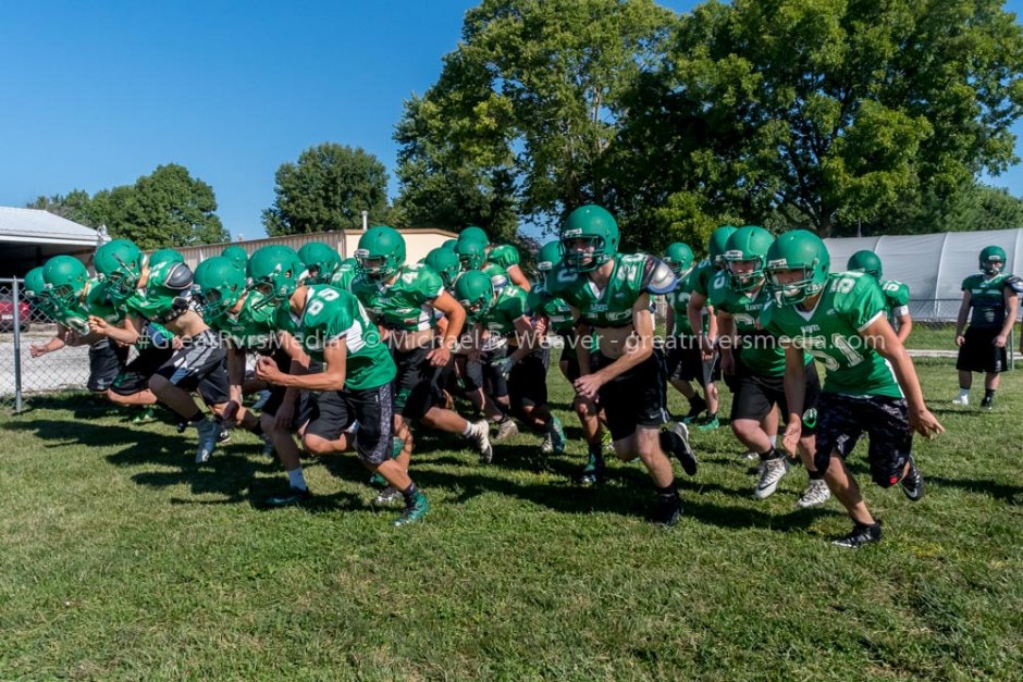 Carrollton players start a mile run after Coach Flowers gave his team times to beat for a mile run or face pushups if they failed.